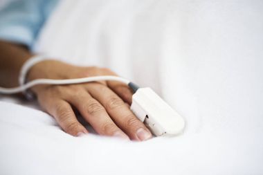 Closeup of hand with finger pulse oximeter, original photoset clipart