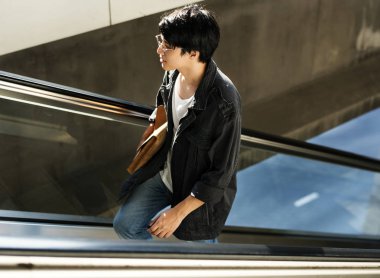 Yakışıklı Asya'ya ait adam yürüyen merdiven üzerinde