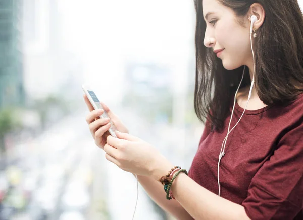 Mujer escuchando música desde el teléfono móvil —  Fotos de Stock