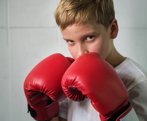 Pojke boxning i rutan handskar — Stockfoto