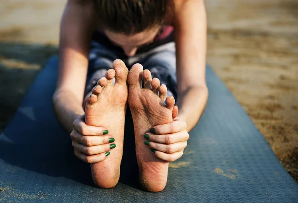 Kvinnan är stretching på stranden — Stockfoto