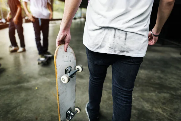 Patinador sosteniendo monopatín en skate park —  Fotos de Stock