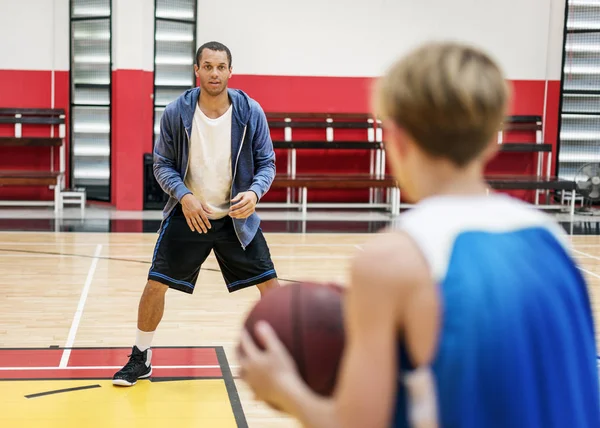Sportsman undervisning pojke att spela basket — Stockfoto