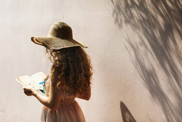 Frau mit Strohhut liest Buch — Stockfoto