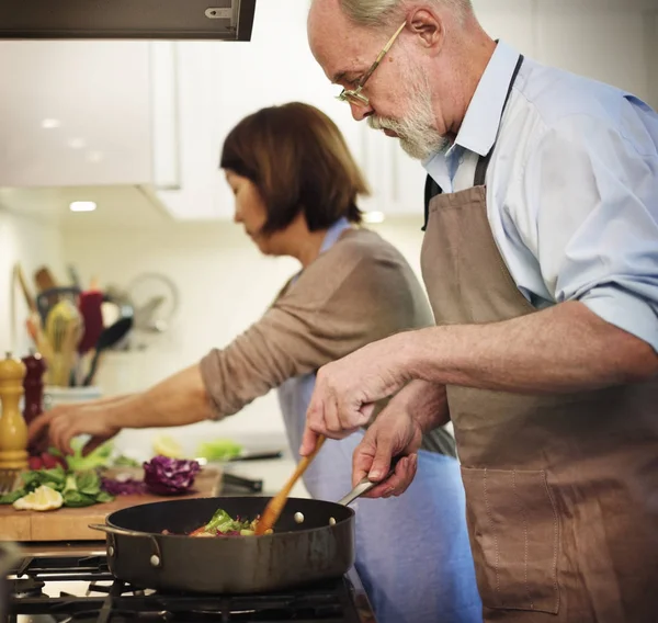 Старша пара готує на кухні — стокове фото