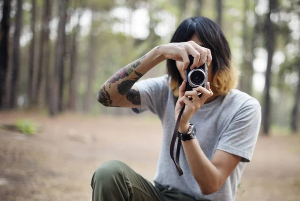 Tattooed photographer in the forest — Stock Photo, Image