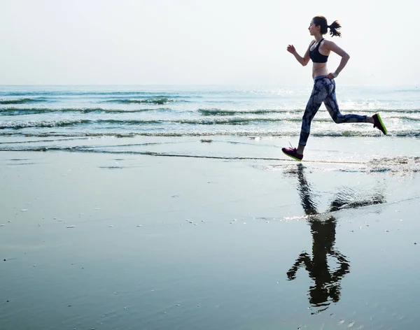 Mujer está corriendo en la playa —  Fotos de Stock