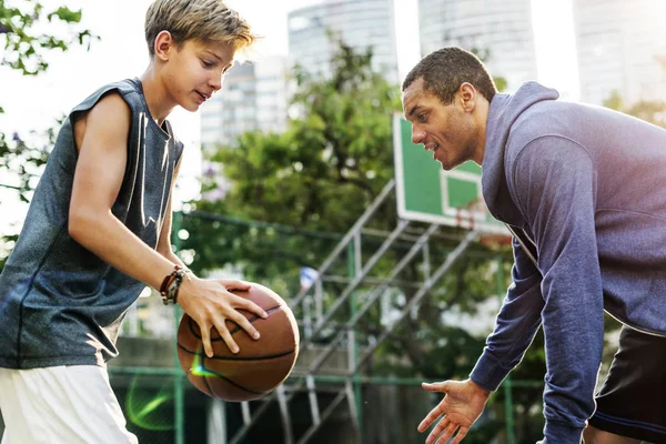 Esportista ensinando menino para jogar basquete — Fotografia de Stock