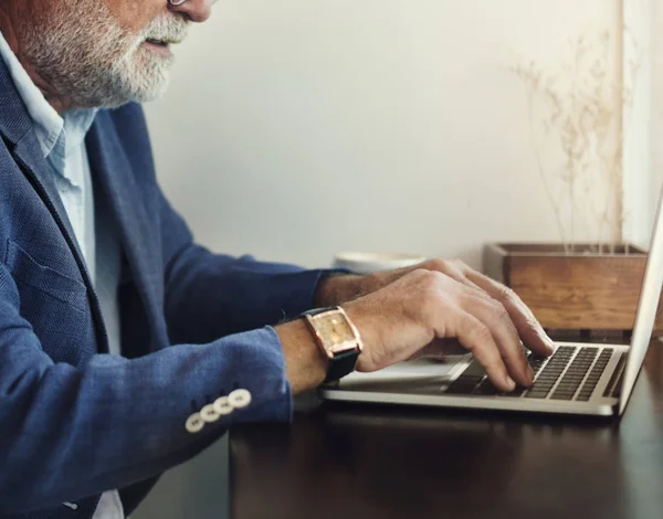 Oudere man is met behulp van computer laptop — Stockfoto