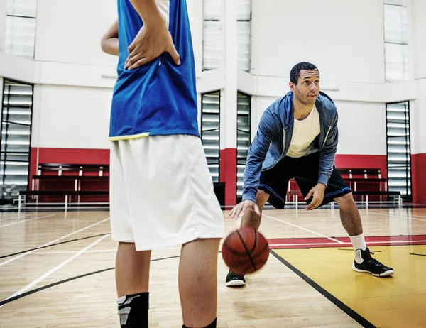 Esportista ensinando menino para jogar basquete — Fotografia de Stock