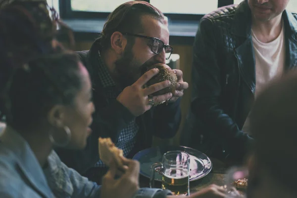 Amigos todos juntos no restaurante tendo refeição — Fotografia de Stock