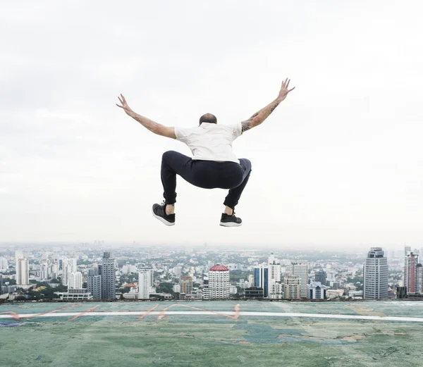 Homem pulando no telhado — Fotografia de Stock