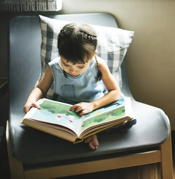 Маленькая девочка читает в книге — стоковое фото