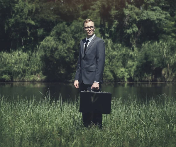 Businessman standing on grassland — Stock Photo, Image