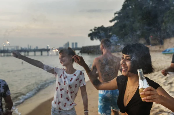 Friends enjoying sparklers at the beach Royalty Free Stock Images