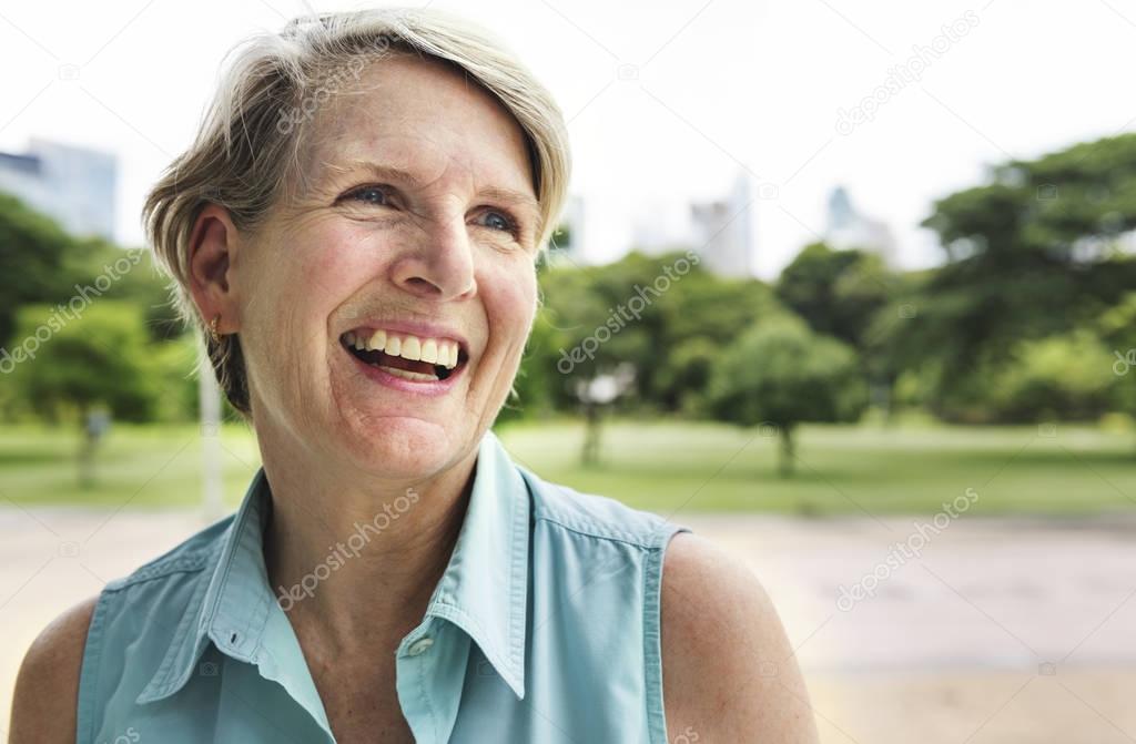 Elderly woman smiling in park, original photoset