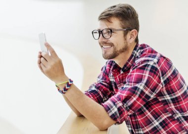 Genç adam akıllı telefon kullanıyor.