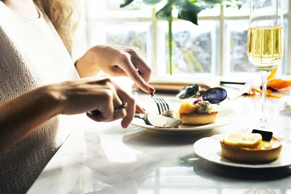 Mujer está comiendo pastelería en restaurante — Foto de Stock