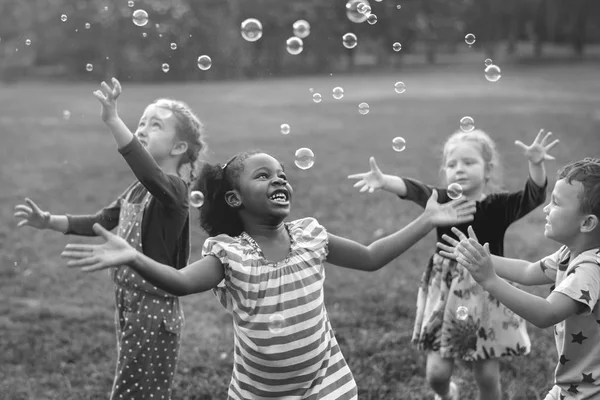 Дети играют с мыльными пузырями — стоковое фото