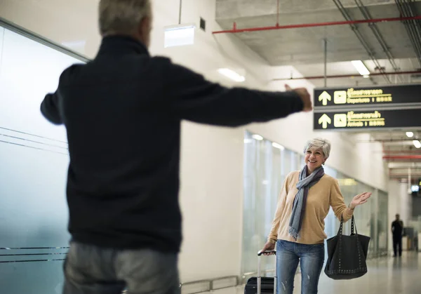 Velho pegando sua mulher no aeroporto — Fotografia de Stock
