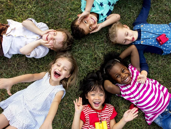 Niños tumbados en la hierba — Foto de Stock