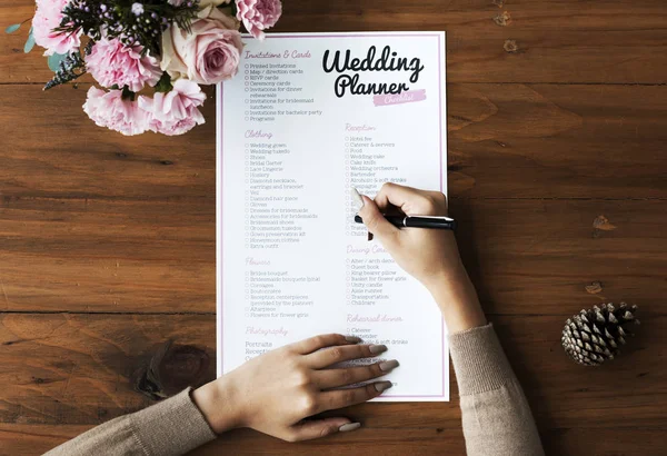 Mãos verificando em Planejador de casamento Checklist — Fotografia de Stock