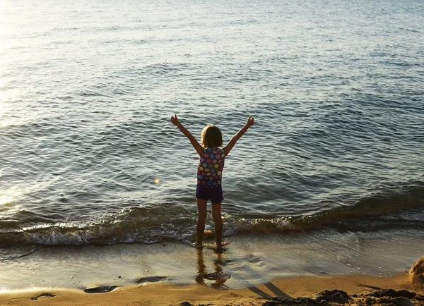 Девушка с поднятыми руками на пляже — стоковое фото