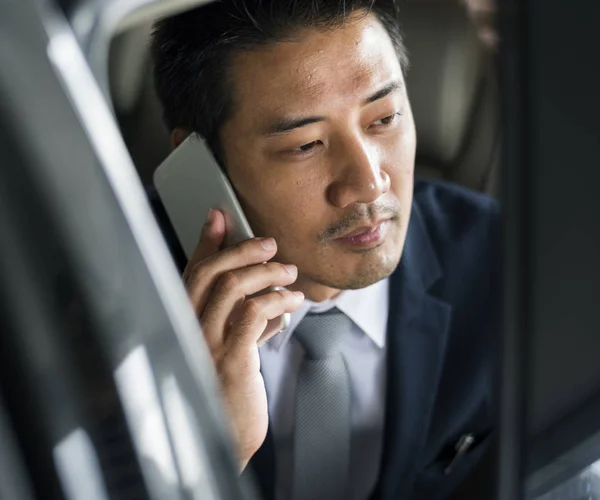 Uomo d'affari sedersi dentro uso auto cellulare — Foto Stock
