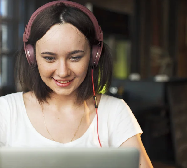 Frau mit Kopfhörer benutzt Laptop — Stockfoto