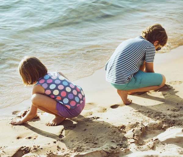 Маленькі діти грають пісок біля берега моря — стокове фото