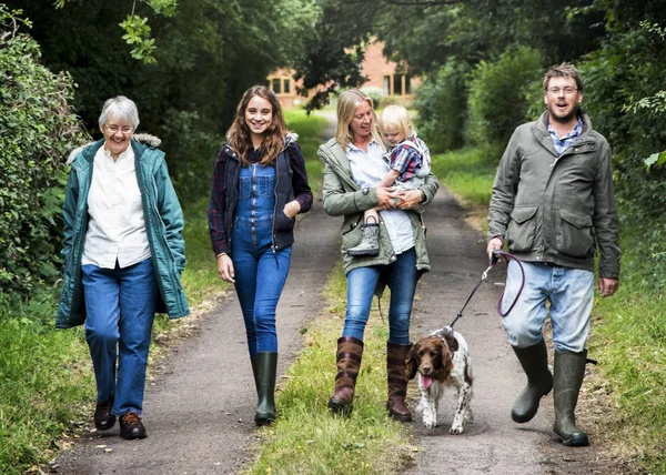 Family with dog walking in park — Stock Photo, Image