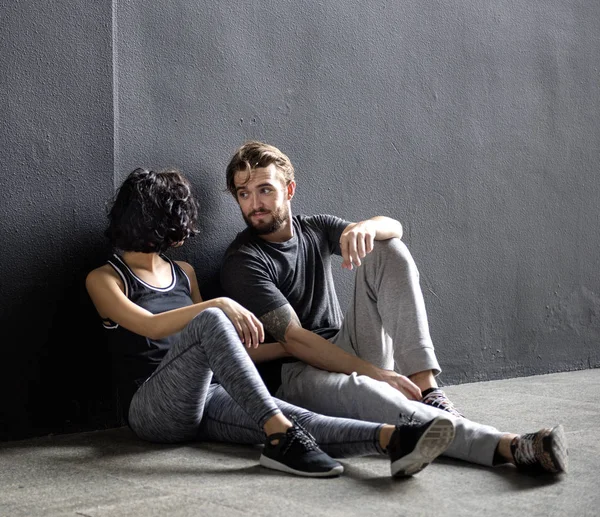 Casal relaxante após estagiário no chão — Fotografia de Stock