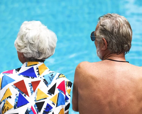 Старшая пара, сидящая у бассейна — стоковое фото