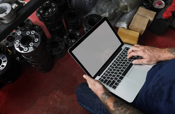 En mekaniker som jobbade med sin laptop — Stockfoto