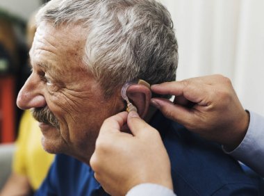 Doktor hastanın kulak, orijinal için işitme cihazı ekleme photoset