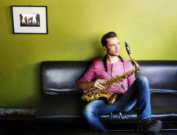 Músico sosteniendo saxofón —  Fotos de Stock