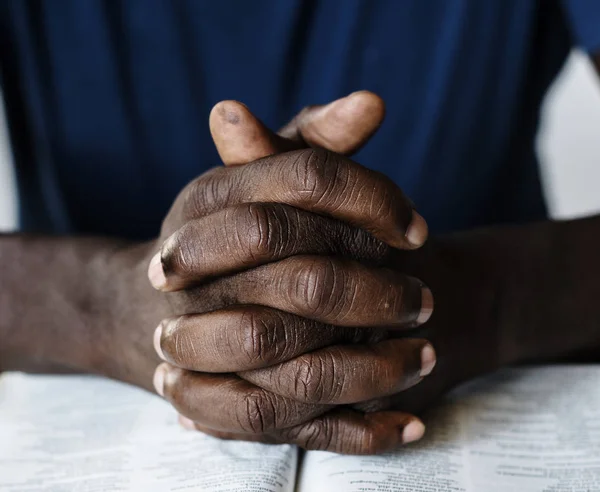 Pessoa orando com livro bíblico — Fotografia de Stock