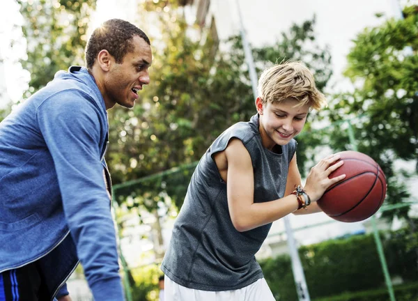 Esportista ensinando menino para jogar basquete — Fotografia de Stock