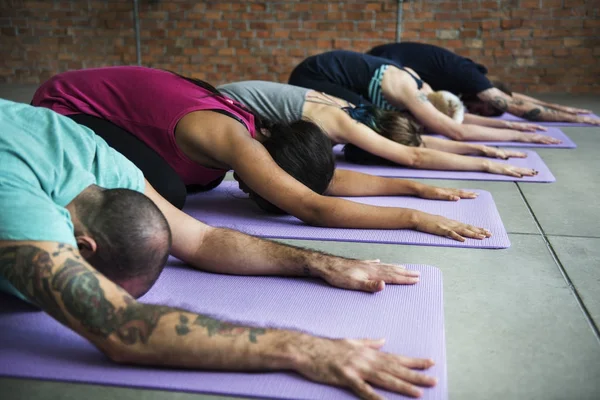 Group of diverse people lying on yoga mat and practicing yoga