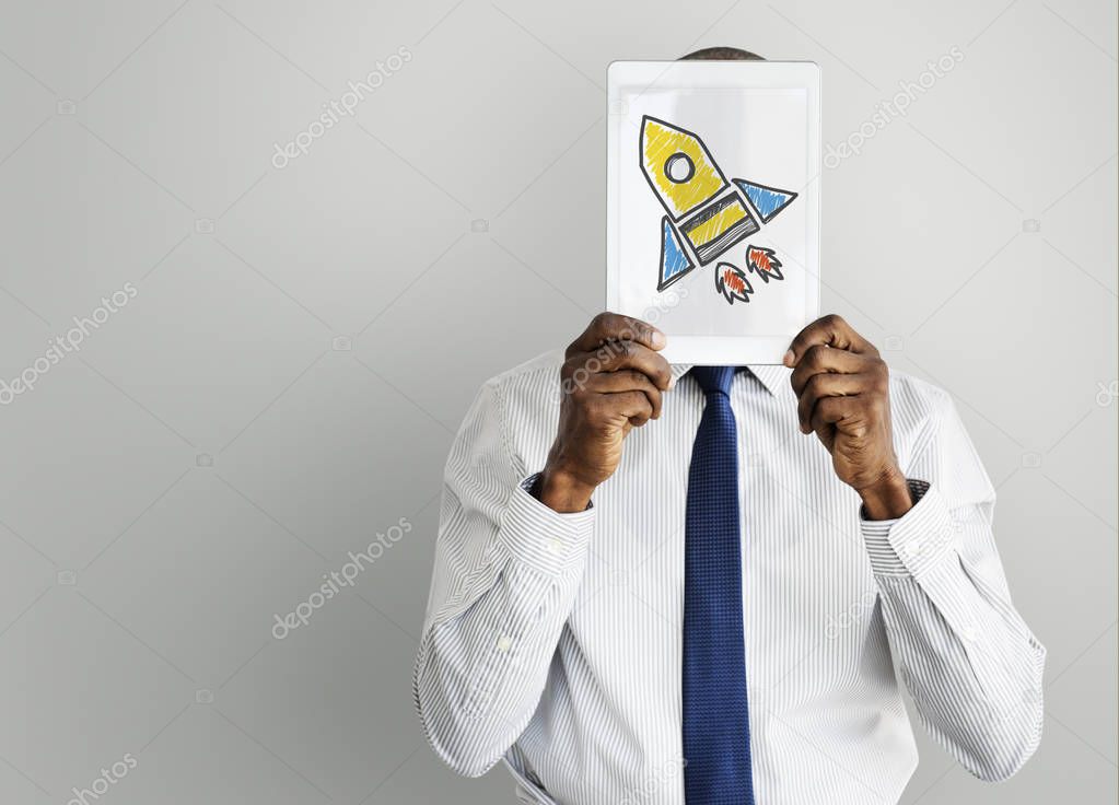 Businessman holding tablet with rocket spaceship icon