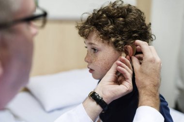 Young boy having his ears checked, original photoset clipart