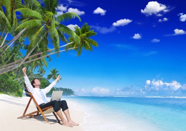 Kumsalda dinlenme dizüstü bilgisayar ile işadamı