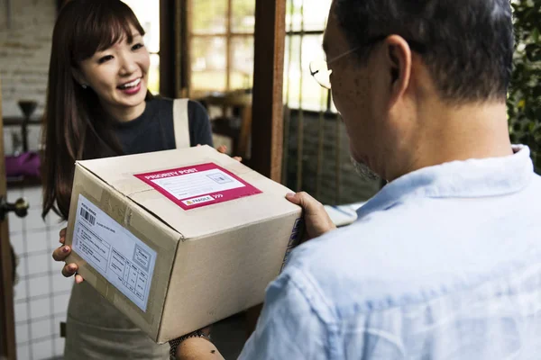 Woman receiving a box delivered to her, original photoset