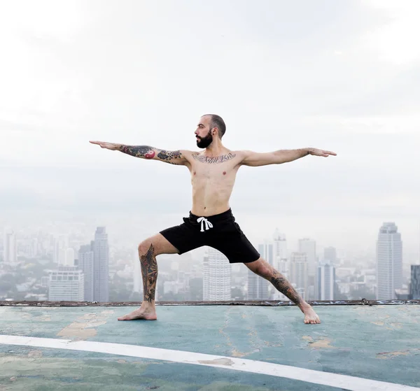 Homem praticando Yoga no telhado — Fotografia de Stock