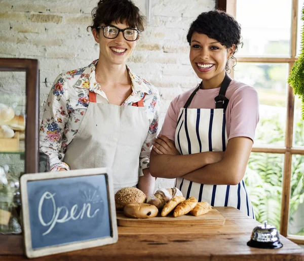 Donne amiche al negozio di panetteria sorridente — Foto Stock