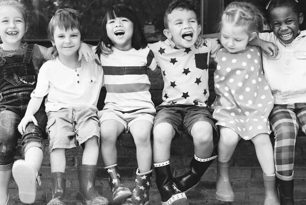 Grupa Przedszkola Dla Dzieci Znajomych Ramię Wokół Siedzi Uśmiechający Się — Zdjęcie stockowe