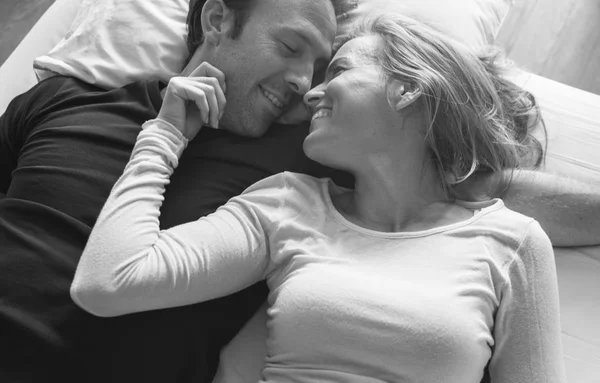 Пара лежить і посміхається в ліжку — стокове фото