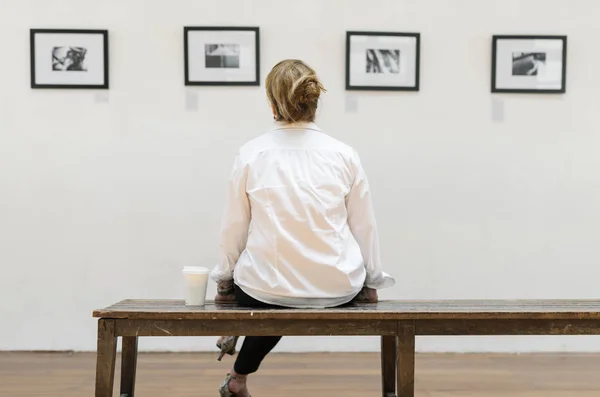 Back View Woman Sits Bench Looking Frames Pictures Exhibition Original — Stock Photo, Image
