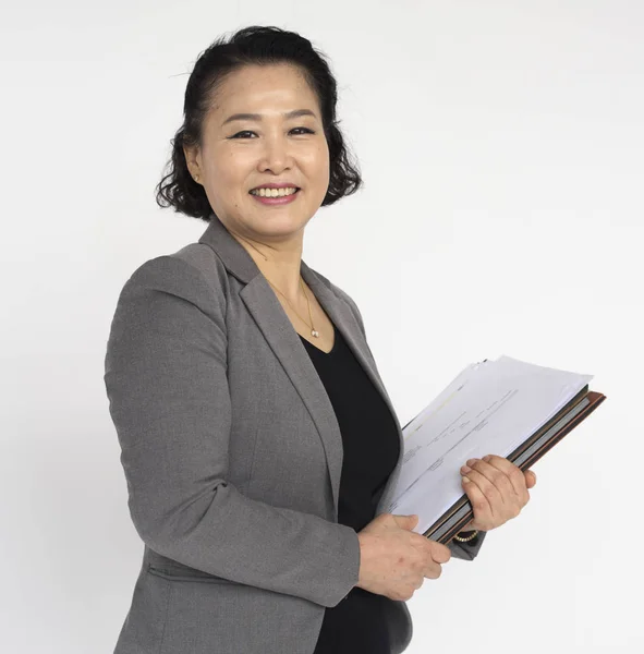 Взрослая азиатка, позирующая с документами — стоковое фото