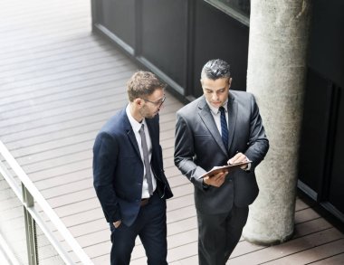 Yürüyüş ve kullanma dijital tablet, özgün photoset iki işadamları